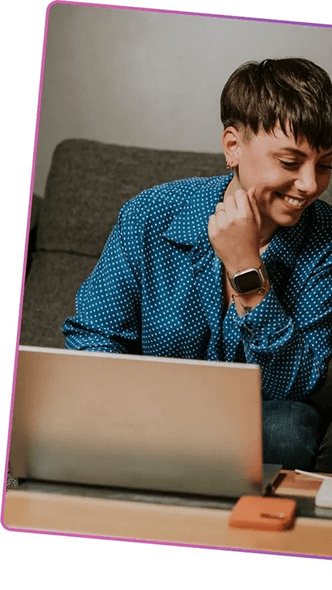 Woman smiling while working on a laptop