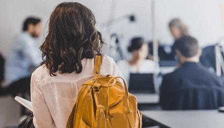Young professional carrying a backpack in a modern office